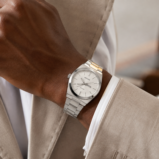 Montre homme argentée portée avec une tenue élégante beige
